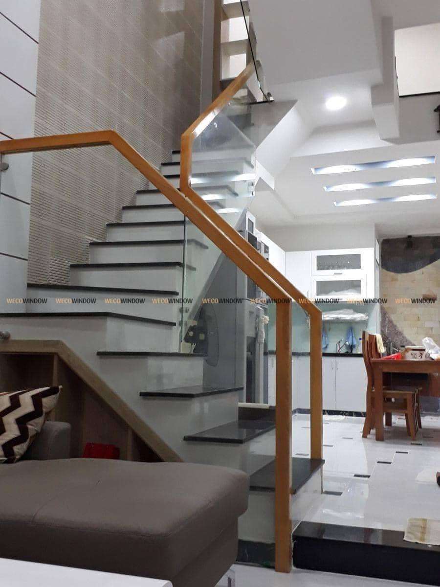 Cầu thang kính tay vịn gỗ vuông. 