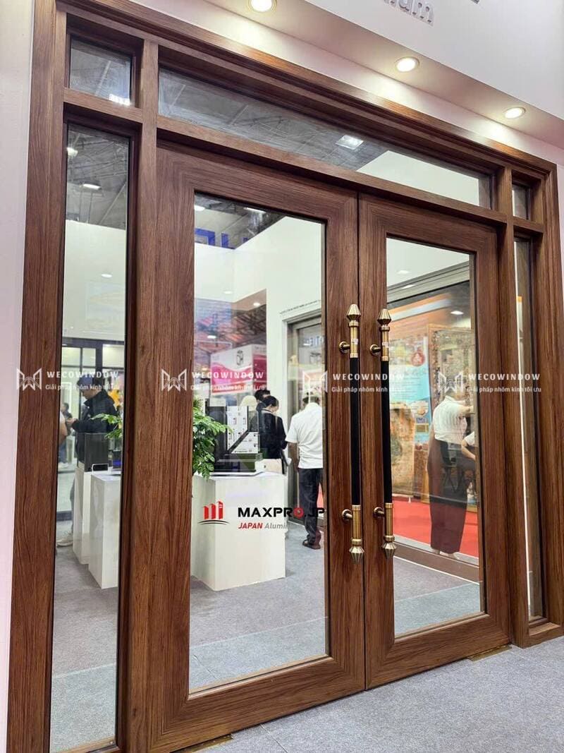 Mẫu cửa nhôm kính đẹp 2026 – 99+ Mẫu hiện đại, sang trọng 67 Cửa nhôm thủy lực đẳng cấp màu vân gỗ rất hợp để lắp cho biệt thự.